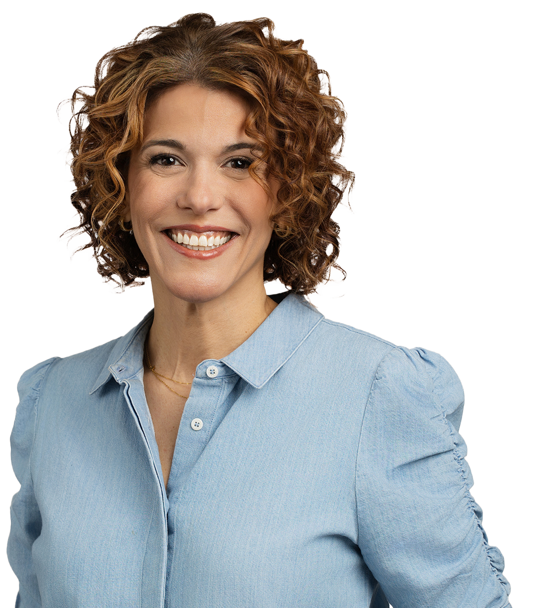 A person with curly hair and a blue button-up shirt smiling against a plain background in a headshot taken by Denver Headshot Co.